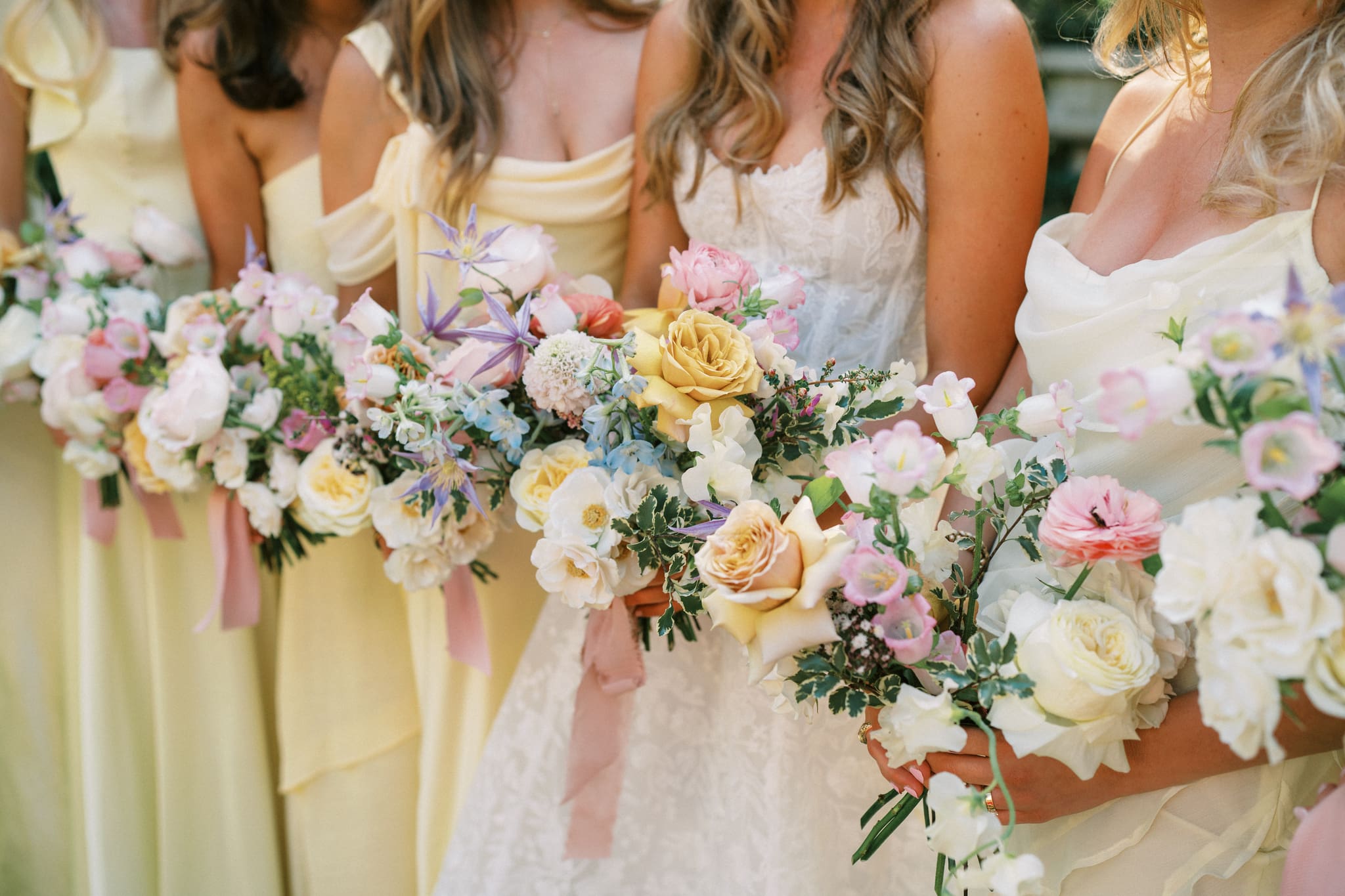 bridesmaids in yellow dresses with bouquets at a wedding at the junior league of houston