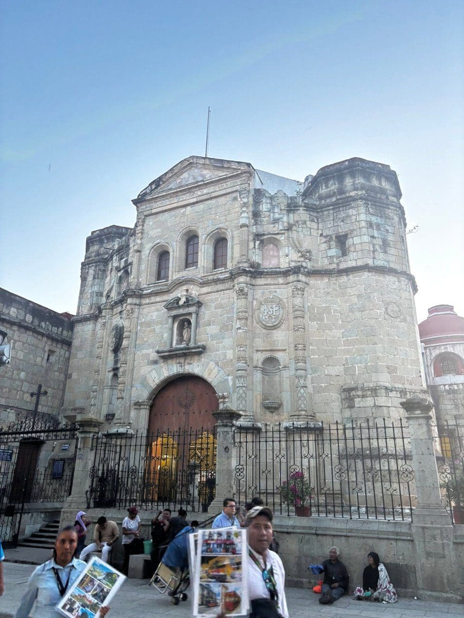 Historic stone church facade with a carved wooden door in Oaxaca City